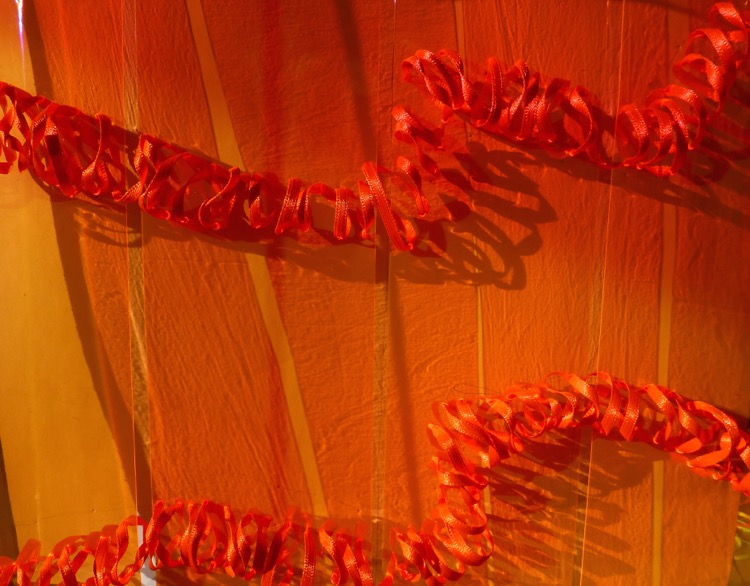 Ribbon stitched through edge lit material